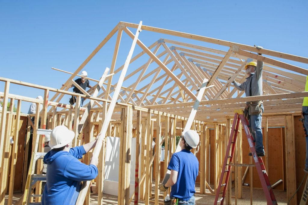 Volunteers Raising Roof Trusses at the Build Site