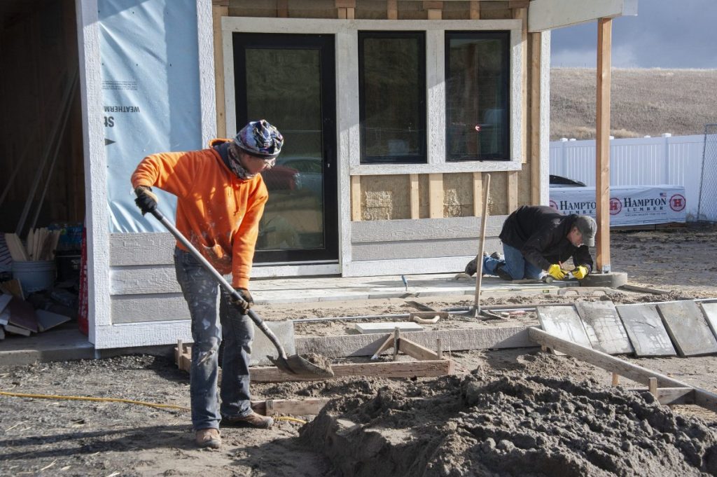 Volunteers Chris and Dave Laying Pavers for the Front Porch at the build site.
