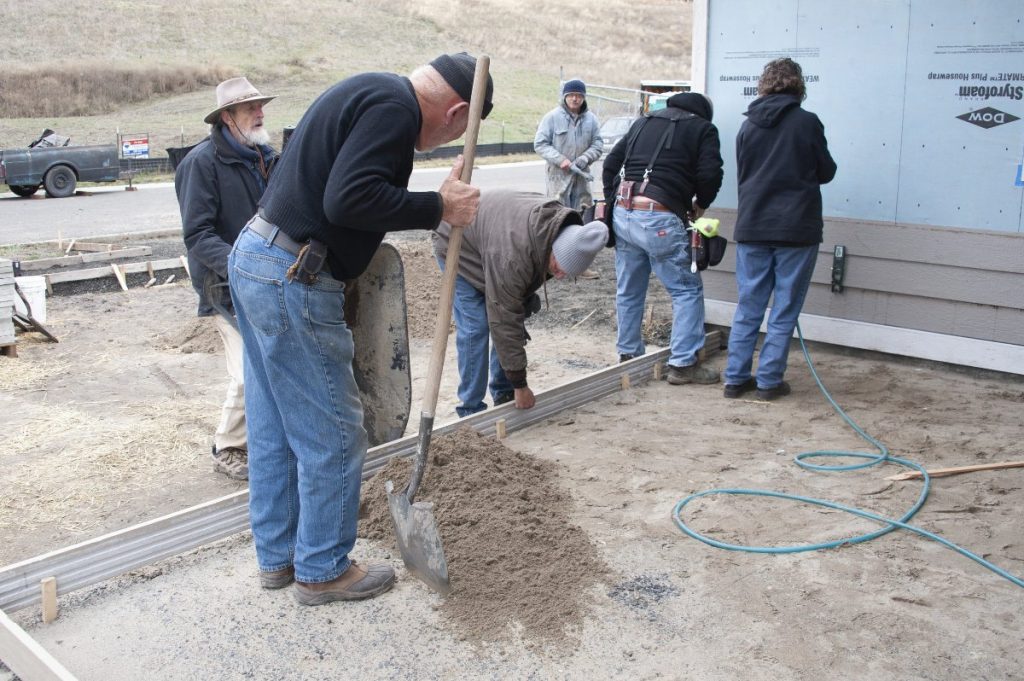 Volunteers Prepping for the Front Porch and Hanging Siding at the build site.