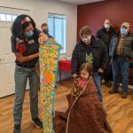Volunteer presenting the Leaseburg family with a quilt at their Home Dedication Event