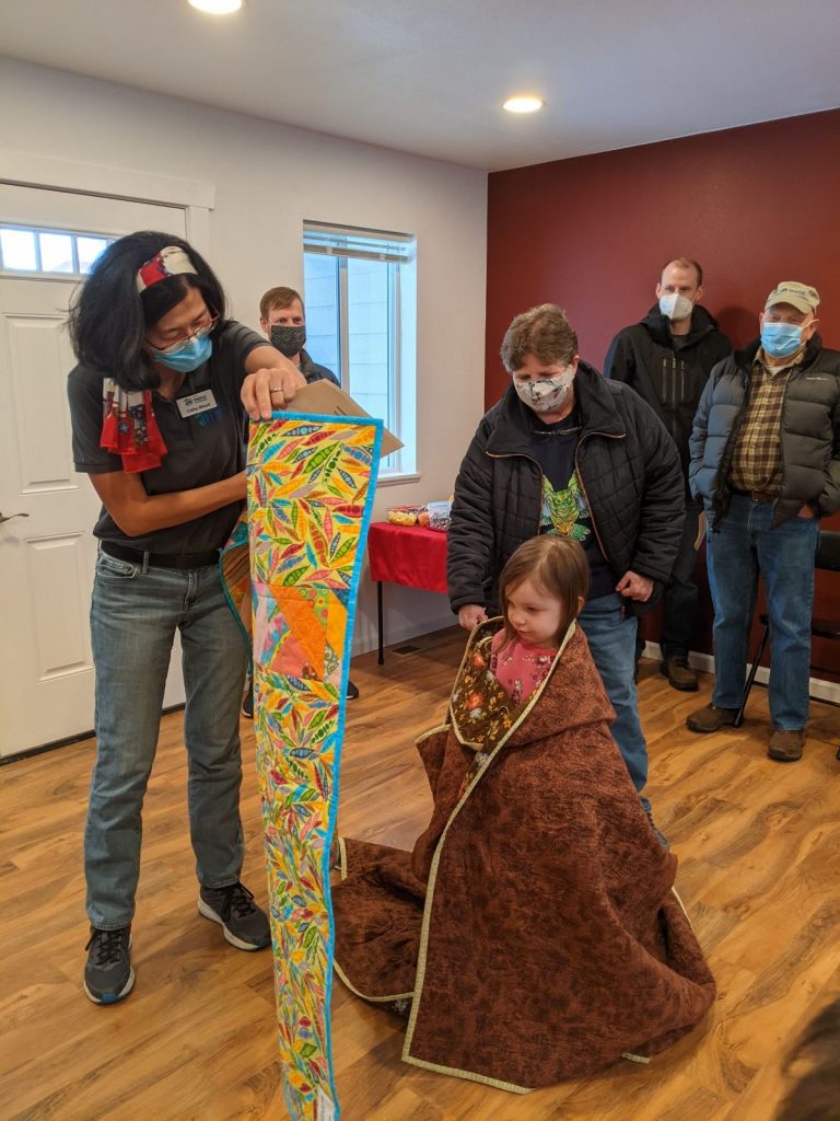 The Leaseburg Family enjoys the homemade quilts gifted to the family at their home dedication event.