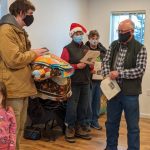 The Leaseburg family accepts some donated, handmade quilts during the Leaseburg Home Dedication Event.