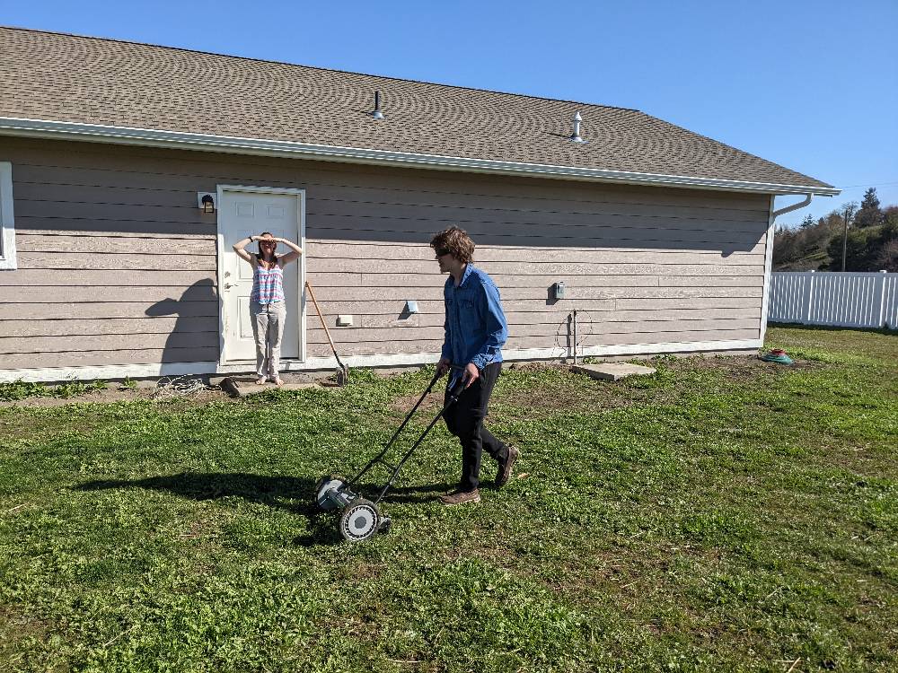 Volunteer mowing the lawn at the Leaseburg Build Site.