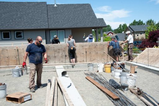 Volunteers work to install stem wall forms at a build site.